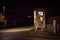 girl speaks in the night telephone booth. mystical and mysterious street phone