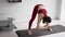 Girl in sport outfit stretching on yoga mat and listening favorite songs in headphones
