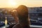 A girl in a sports suit holds a huge piece of pizza and bottle of mojito on the sunset city background