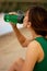 a girl in a sports uniform holds a bottle in her hand, a girl drinks water from a bottle, a girl is dressed in a green tracksuit