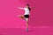 Girl sportsman posing on a pink background