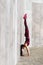 A girl with a sporty build performs a handstand exercise on a street playground