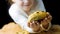 The girl spreads a loaf of freshly baked toasted bread with pumpkin seeds in the frame. In the background is a romantic