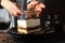 Girl sprinkles powder on tiramisu Composition with tasty cake on wooden background