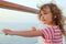 Girl standing on cruise liner deck, hands on rail