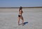 Girl standing on the dry bottom of a salt lake