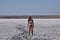 Girl standing on the dry bottom of a salt lake