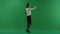 Girl is standing on her right side and making a selfie on green screen