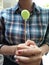 A girl standing holding a green candy stick.