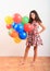 Girl standing with inflating balloons