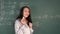 Girl standing near blackboard with mathematical