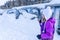 A girl standing near magicagic carpet ski lift in a glass tunel. Snowy winter day in the french ski resort.