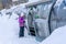 A girl standing near magicagic carpet ski lift in a glass tunel. Snowy winter day in the french ski resort.