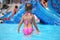 Girl standing in pool in aquapark, standing back