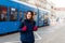 Girl standing in station with tram passing by