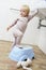 Girl Standing On Step In bathroom To Reach Sink