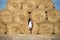 Girl standing beside straw bale