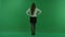 The girl stands back to the camera, arms is on her waist, she is waiting for something on green screen