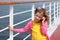 Girl stands on board ship, talks by portable radio