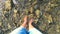 Girl stands at the bottom of a rocky shallow river in the mountains