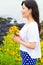 Girl stands in daisy sunflower field near the beach