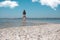 A girl stands on the edge of a sea beach