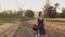 Girl stands in a field next to her bicycle and looks around at beautiful nature