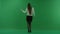 The girl stands with her back to the camera and dances, moving her hands on green screen