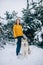 Girl stands next to a dog Alaskan Malamute in winter forest