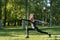 Girl stands in the pose of a warrior, girl in a  black jacket, sports, yoga in the Park