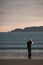 A girl stands on the shore of the Barents Sea at sunrise