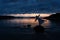 A girl stands on the shore of the Barents Sea at sunrise