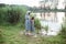 A girl stands on the shore of the lake and looks at nutria in the water