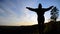 A girl stands on top of a mountain with her hands open. Freedom in the gesture.