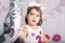 A girl stares at a funny-faced balloon on a white background