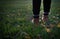 Girl steps on the grass at sunset