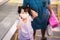 Girl stood on escalator. Child wave their hands to the camera. Kid wearing cloth mask in shopping mall. Children hand in hand with