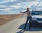 Girl stops the car, raising his hand on a deserted road.