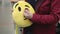 Girl in store buys funny pillow in form of yellow smiley face for car seat