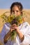Girl on straw field with wildflower bouquet on hand