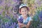 Girl in a straw hat in a field of lavender with a basket of lavender. A girl in a lavender field. Girl with a bouquet of lavender.