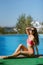 girl in a straw hat and a pink bathing suit country pool