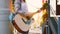 Girl street musician, in shirt, playing guitar slow mo unrecognizable