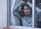 Girl in stress at home - dramatic portrait of young sad and depressed Asian Korean woman on window feeling worried and desperate