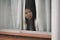 Girl in stress at home - dramatic portrait of young sad and depressed Asian Korean woman on window feeling worried and desperate