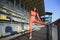 Girl stretches, prepares her body and muscles for a productive fitness workout. Flexible female dressed sports suit sporty model