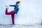 Girl stretching out her leg doing yoga exercise - blue wall copy space