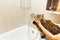 Girl strokes a fluffy cat on a white washbasin in the bathroom
