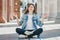 Girl student sitting on the floor and meditating and asks for a good grade in the exam