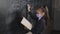 A girl student solves equations at the blackboard in a medical mask.